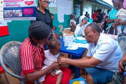 Mother and child with UNICEF health worker Ezeugwu at a measles vaccination injection campaign