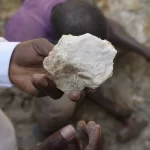 A man shows lithium stone - Souce: (AP Photo/Sunday Alamba)