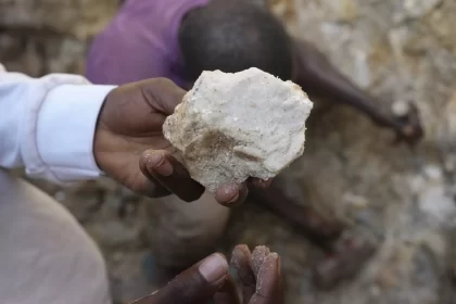 A man shows lithium stone - Souce: (AP Photo/Sunday Alamba)