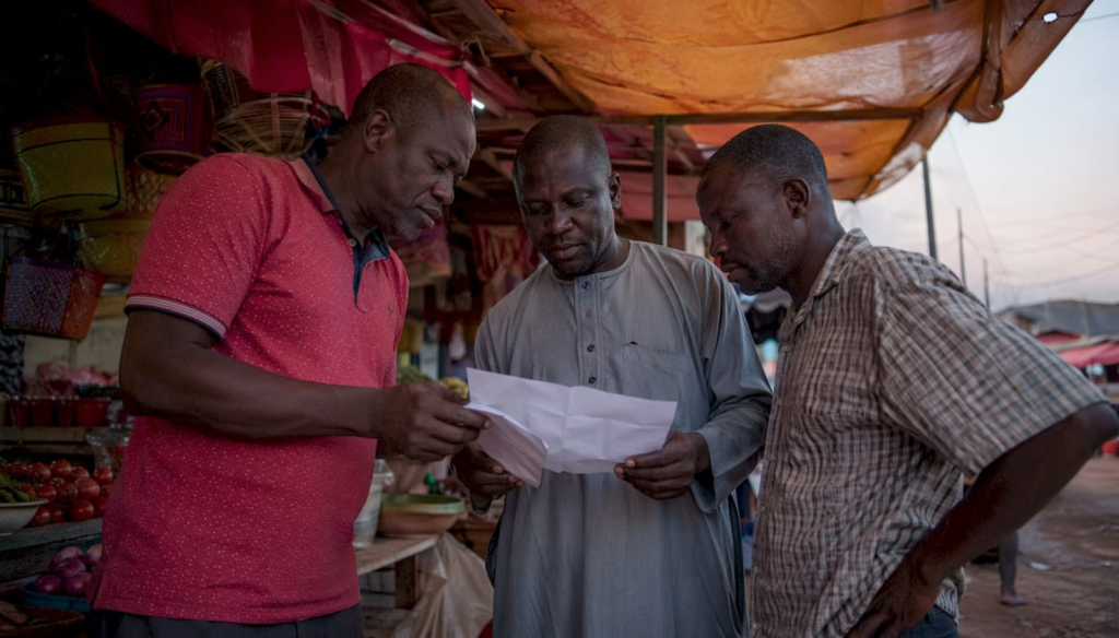 Workers discussing wages outdoors in northern Nigeria